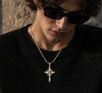 Men's Gold Gothic Cross Pendant Necklace Styled with a Black Knit Sweater and Sunglasses